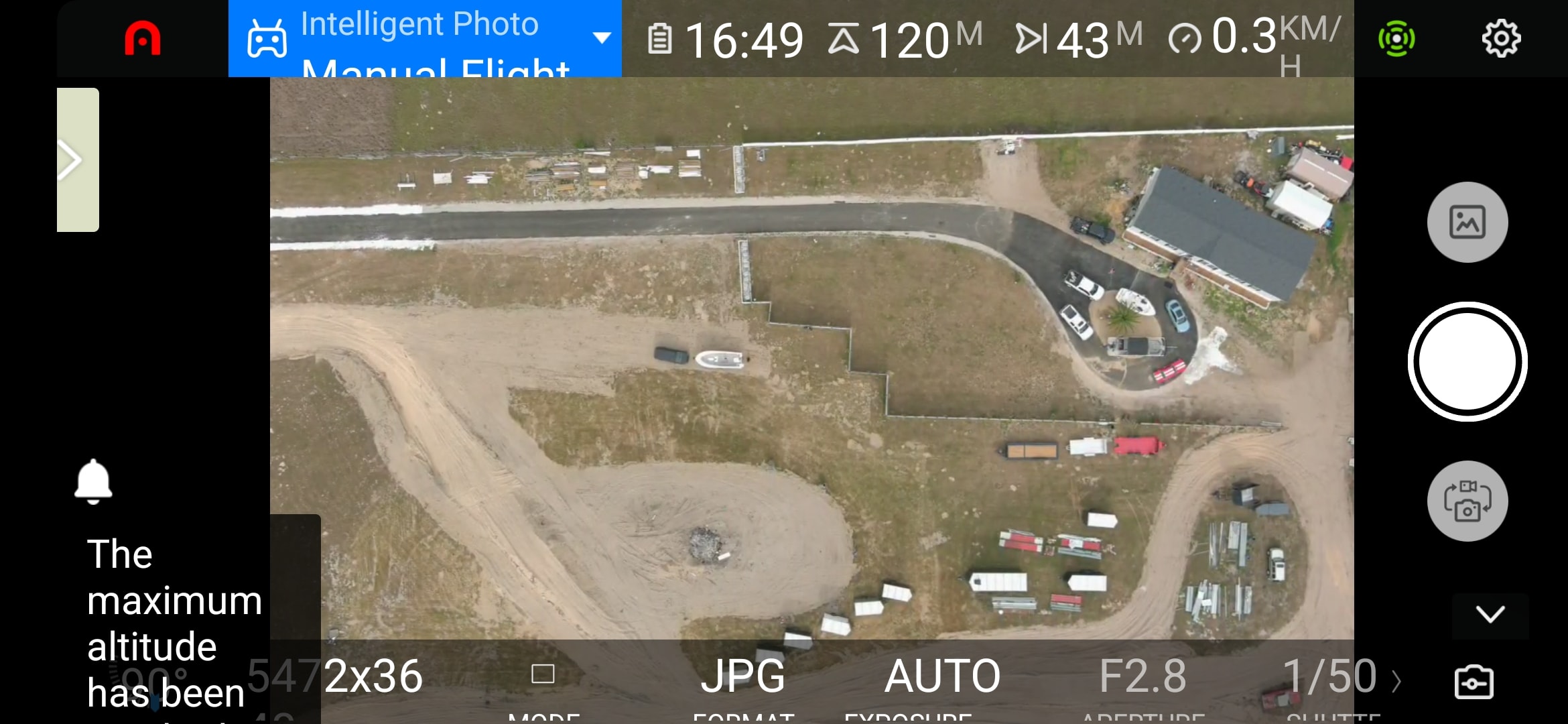 Drone photograph taken at 120m altitude showing an active construction and staging yard with equipment and materials.