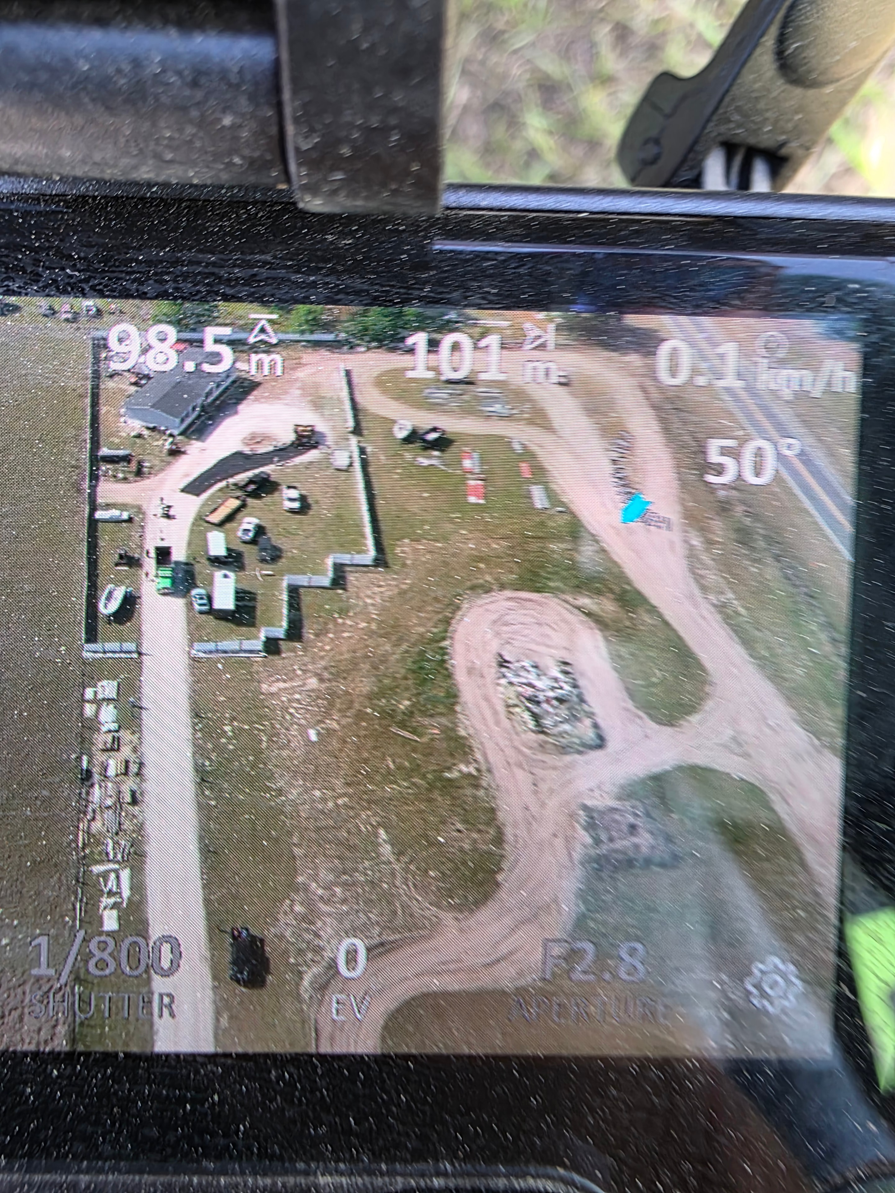 Drone controller screen showing aerial view of an active Red Star development site with roads and structures.