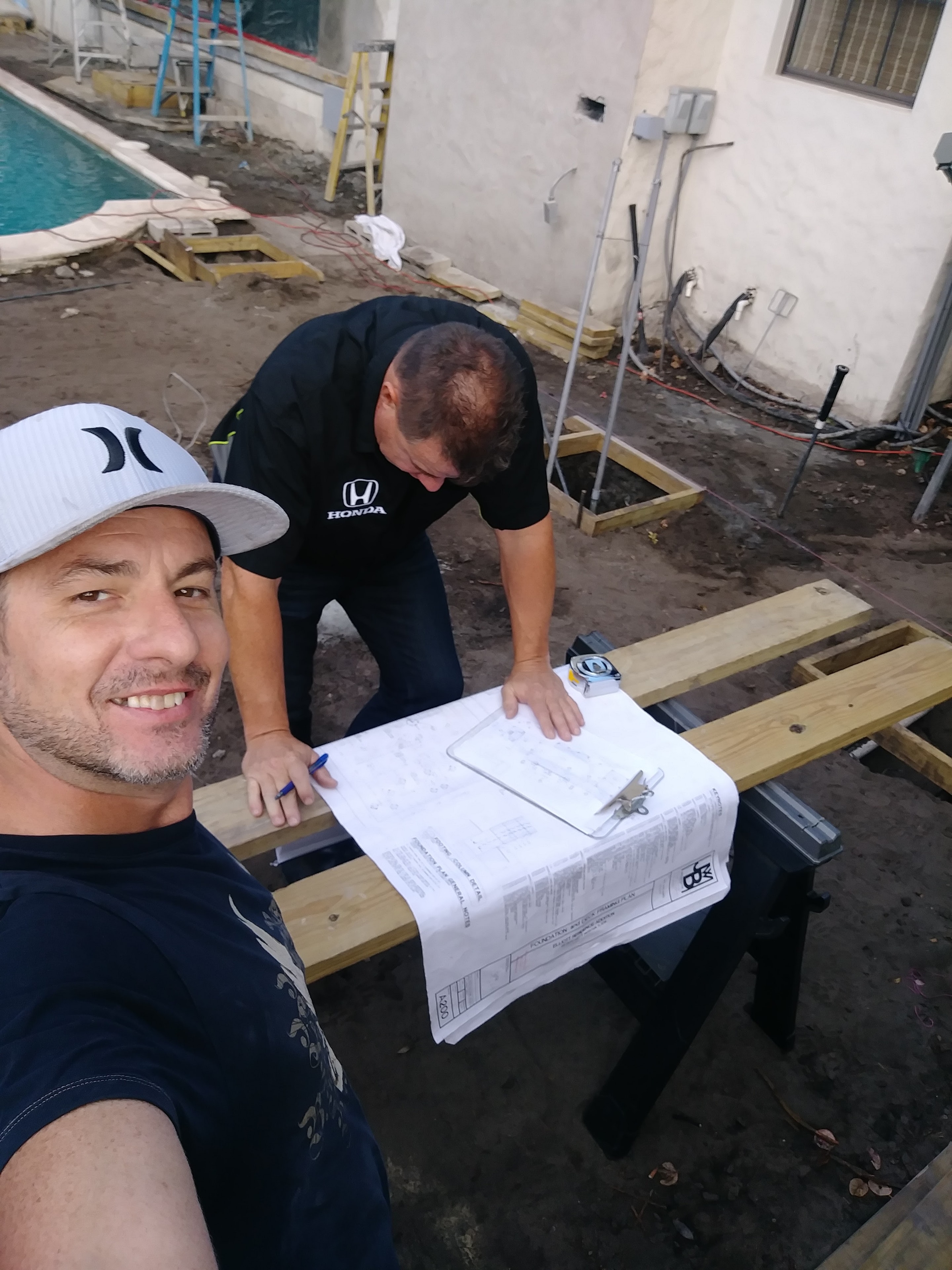 David Gilley and a colleague reviewing Phil Kean architectural blueprints on-site during the Gilley Residence renovation.