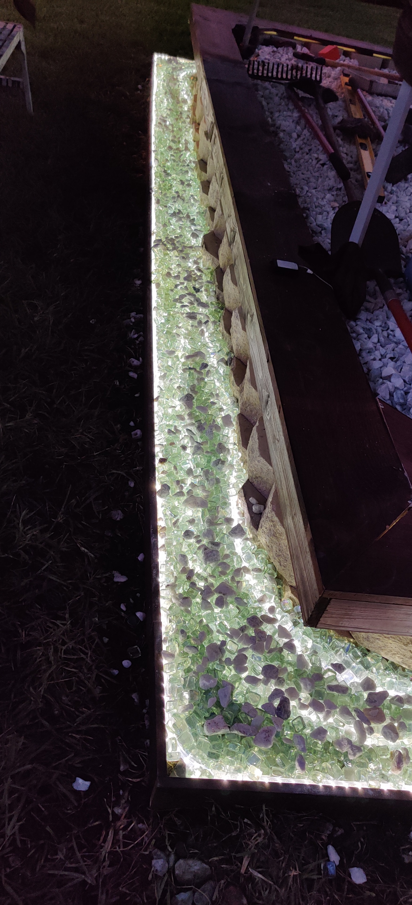Close-up of a custom illuminated glass rock and stone planter with LED strip lighting, a Red Star luxury detail.
