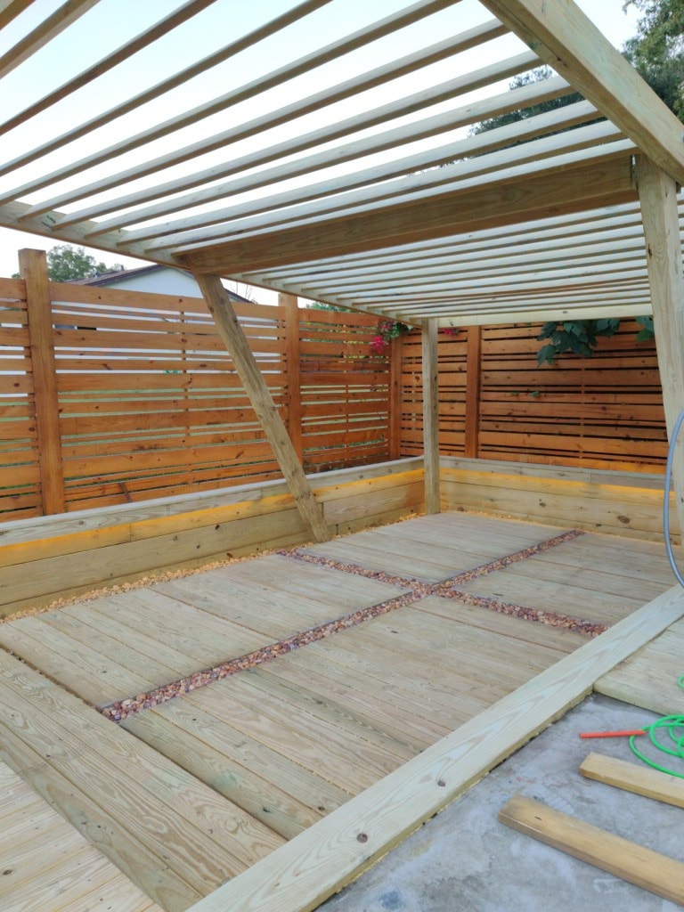 Completed pergola structure with privacy fence and deck flooring at a Red Star residential project.