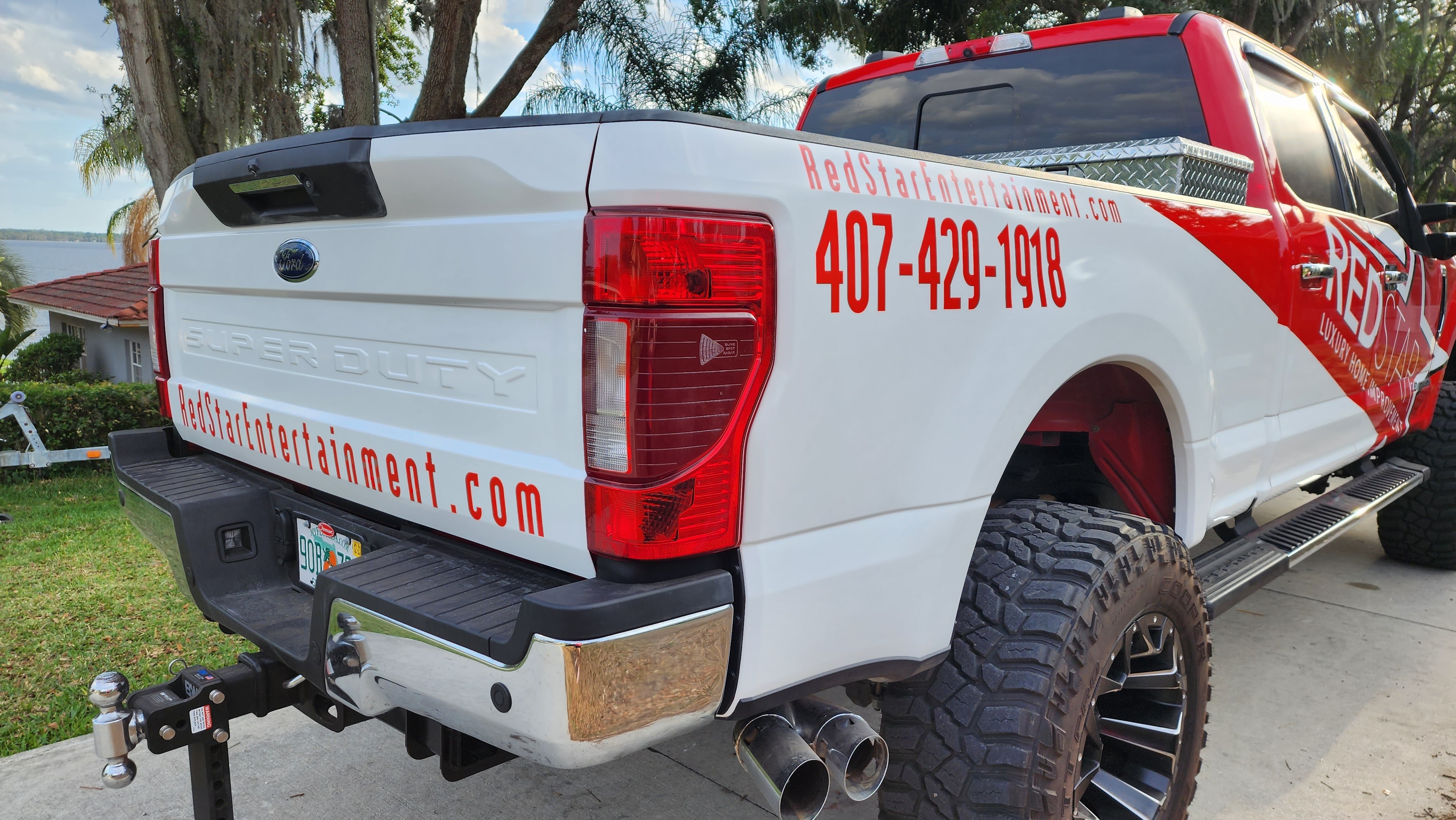 Rear view of the Red Star Super Duty truck showing the tailgate wrap with 407-429-1918 and RedStarEntertainment.com.